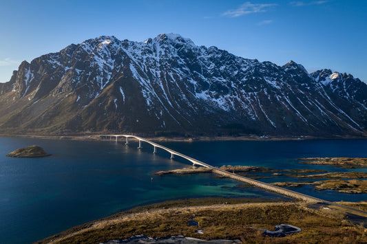 Aerial drone view of bridge connecting Lofoten islands over blue ocean, Norway