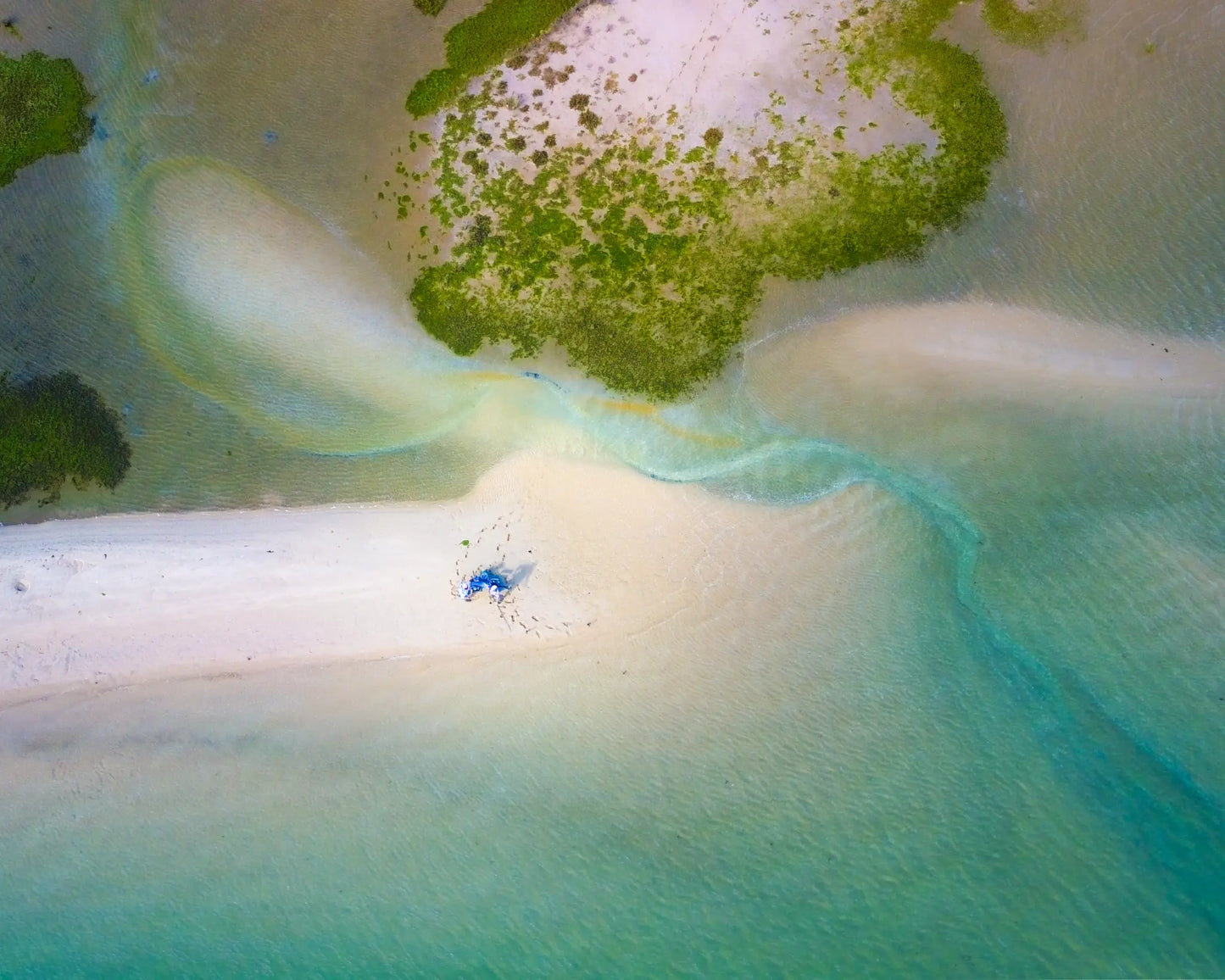 Aerial view of white sandbar with blue umbrella and turquoise lagoon water, Tavira, Algarve, Portugal