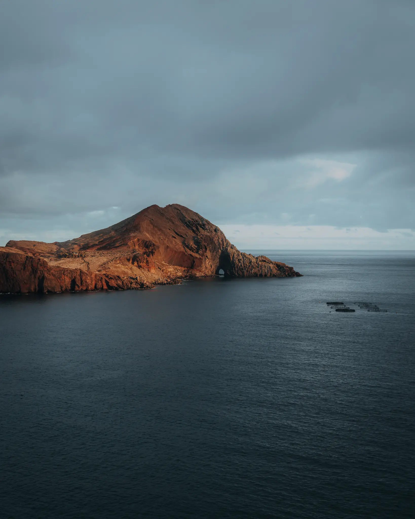 Volcanic headland with sea arch in warm afternoon light, Madeira, Portugal